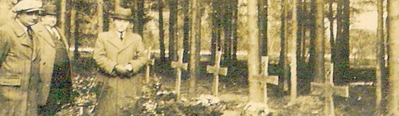 Visitors at the War Cemetery in Nunkirchen during winter 1944/45  
standing beside several wooden cross grave marker located within the pinewood forest along the road L-152.
